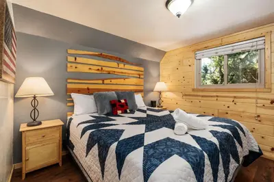 a bedroom with a black and white bed and a window at Blue Meadow-Family Pet Friendly & near the lake in Shaver Lake