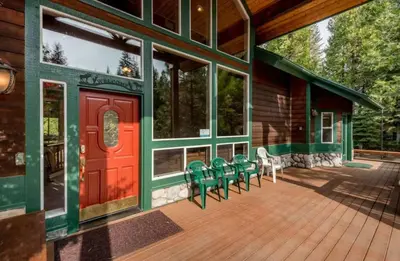 a deck with chairs and a red door on a house at Handels Pride- Family friendly Game Room & Views in Shaver Lake