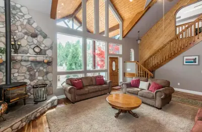 a living room with two couches and a stone fireplace at Handels Pride- Family friendly Game Room & Views in Shaver Lake