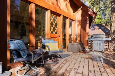 a screened in porch with chairs and a grill at Nana & Papas-Family Friendly in East Village in Shaver Lake