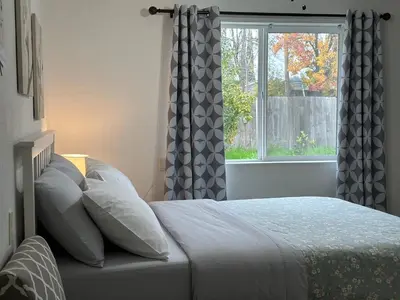 a bedroom with a bed with pillows and a window at Cozy suite B in Sacramento