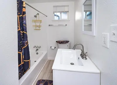 a white bathroom with a sink and a tub at 2 Bedroom Home Near Downtown Zoo Golf Pet-Friendly and Fenced in Sacramento