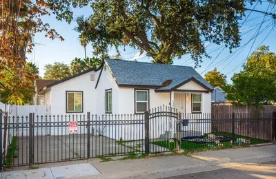a white house with a white picket fence at 2 Bedroom Home Near Downtown Zoo Golf Pet-Friendly and Fenced in Sacramento