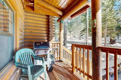 a stroller on the porch of a log cabin at Adventure Ridge Cabin in Truckee