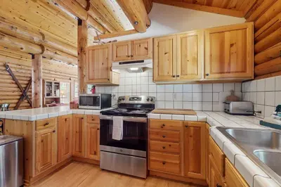 a kitchen with wooden cabinets and a stove top oven at Adventure Ridge Cabin in Truckee