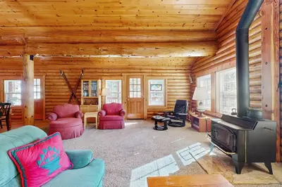 a living room with a fireplace in a log cabin at Adventure Ridge Cabin in Truckee