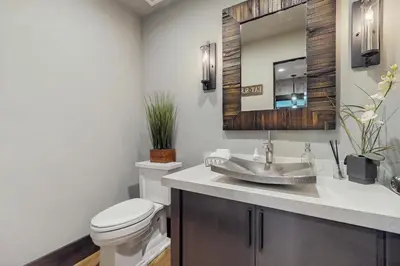 a bathroom with a toilet and a sink with a mirror at Lakeshore Luxe in Incline Village