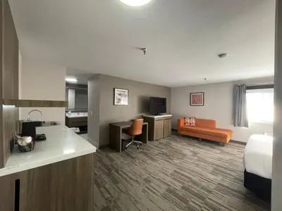 a hotel room with a bed and a kitchen and a couch at Sisk Hotel in Modesto