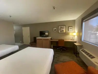 a hotel room with a bed and a desk with a computer at Sisk Hotel in Modesto