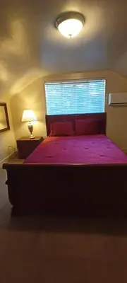 a bedroom with a bed with a purple bedspread and a window at Historic Reno Home in Reno