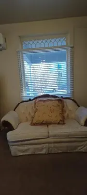 a couch with a pillow in front of a window at Historic Reno Home in Reno