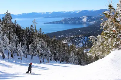 a person riding a snowboard down a snow covered slope at The Treetop Retreat in Incline Village