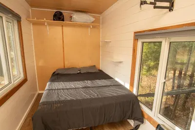 a bed in a small room with a window at Tiny one house at Yosemite Gateway in Groveland