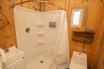 a bathroom with a shower and a toilet and a sink at Tiny one house at Yosemite Gateway in Groveland