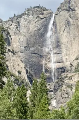 a waterfall on the side of a mountain at Tiny one house at Yosemite Gateway in Groveland