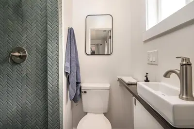 a bathroom with a sink and a toilet and a mirror at Vintage Vine House in Murphys