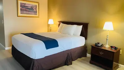 a hotel room with a large bed and a telephone at Rodeway Inn Jackson in Jackson