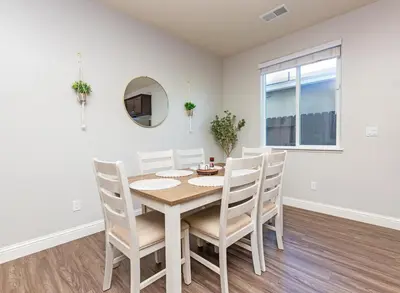 a dining room with a table and chairs and a mirror at New Modern 3bed in North Merced 5 Star hosts in Merced