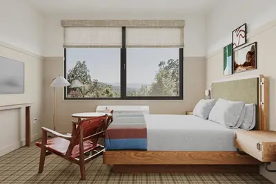 a bedroom with a bed and a chair and a window at Outbound Yosemite in Oakhurst