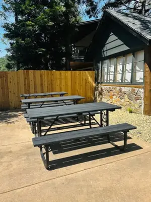 a group of picnic tables in front of a building at Boat Dock - Lake Front - Dog Friendly - Sleeps 23 in Bass Lake