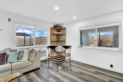 a living room with a couch and two windows at Yosemite Retreat, Views and Hot Tub in Oakhurst
