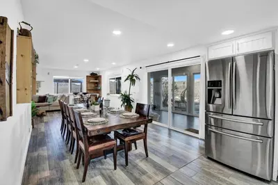 a kitchen and dining room with a table and refrigerator at Yosemite Retreat, Views and Hot Tub in Oakhurst