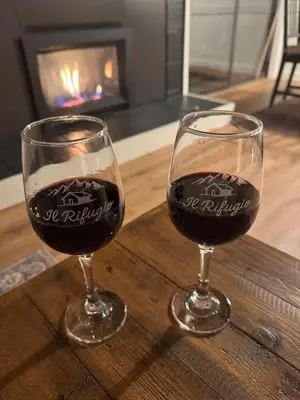 two glasses of wine sitting on a wooden table with a fireplace at Newly Remodeled 2Bd 2Ba Condo in NorthStar in Truckee