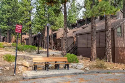 a wooden bench sitting in front of a house at Newly Remodeled 2Bd 2Ba Condo in NorthStar in Truckee