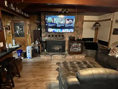 a living room with a fireplace and a flat screen tv at Twain Harte Cozy cabin downtown in Twain Harte