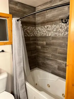 a bathroom with a tub and a toilet at Twain Harte Cozy cabin downtown in Twain Harte