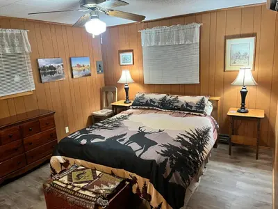 a bedroom with a bed and two tables and two lamps at Twain Harte Cozy cabin downtown in Twain Harte