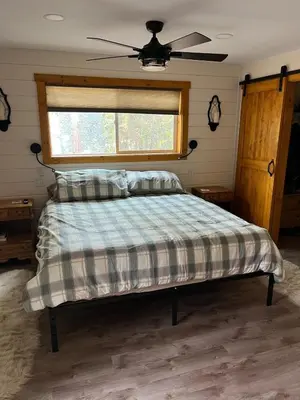 a bedroom with a bed with a ceiling fan at Twain Harte Cozy cabin downtown in Twain Harte
