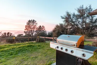 a grill sitting on top of a field at Cold Plunge, Hot Tub, Firepit, BBQ, Pet-Friendly, Sunset Views near Yosemite in Coarsegold