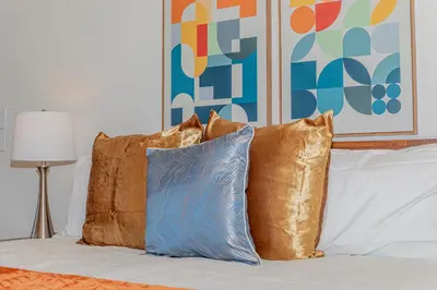 a pile of pillows sitting on top of a bed at Skyfalls Retreat Mid-Century Guesthouse near Yosemite in Oakhurst