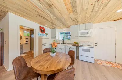 a kitchen with a wooden table and chairs at Skyfalls Retreat Mid-Century Guesthouse near Yosemite in Oakhurst