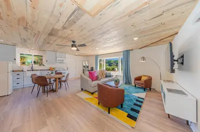 a kitchen and living room with a table and chairs at Skyfalls Retreat Mid-Century Guesthouse near Yosemite in Oakhurst