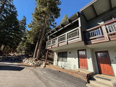 a house with red doors and a driveway at Chateau Doex #8 condo in Mammoth Lakes
