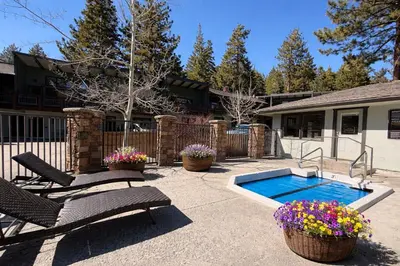 a patio with two chairs and a swimming pool at Chateau Doex #8 condo in Mammoth Lakes