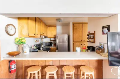 a kitchen with wooden cabinets and a counter with stools at Forest Meadows 8 in Mammoth Lakes
