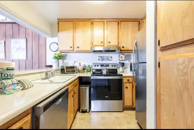 a kitchen with wooden cabinets and stainless steel appliances at Forest Meadows 8 in Mammoth Lakes