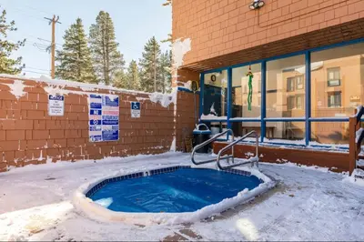 a hot tub in the snow in front of a building at Forest Meadows 8 in Mammoth Lakes
