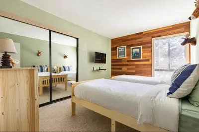 a bedroom with two beds and a living room at Forest Meadows 8 in Mammoth Lakes