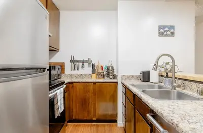 a kitchen with a sink and a refrigerator at Summit 240 in Mammoth Lakes