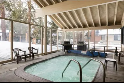 a swimming pool in a pavilion with a snow covered yard at Discovery Four 109 in Mammoth Lakes