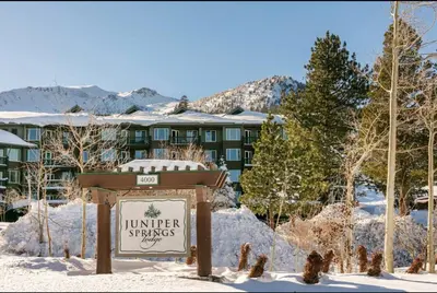 a sign in the snow in front of a hotel at Juniper Springs Lodge 437 in Mammoth Lakes