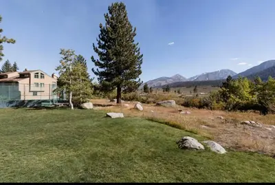 a house in the middle of a field with rocks at Mammoth Creek 29 in Mammoth Lakes