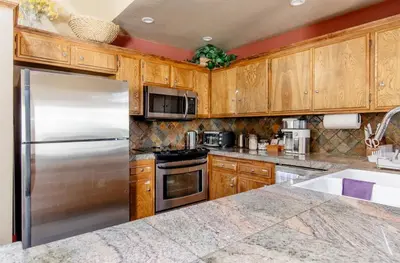 a kitchen with wooden cabinets and a stainless steel refrigerator at Mammoth Estates 138 in Mammoth Lakes