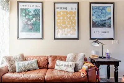 a living room with a brown couch and pictures on the wall at Mammoth Estates 138 in Mammoth Lakes