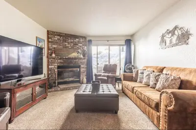 a living room with a couch and a fireplace at Chamonix 17 in Mammoth Lakes