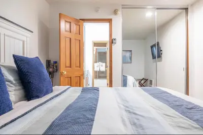 a bedroom with a large bed and a sliding glass door at Chamonix 17 in Mammoth Lakes